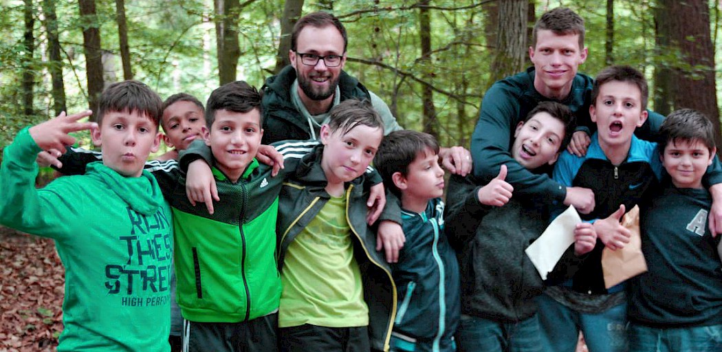 Kinder im Wald mit zweien unserer Erzieher