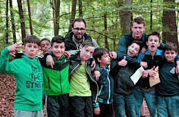 Kinder im Wald mit zweien unserer Erzieher